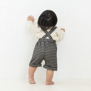 チェック柄のサロペットパンツを履いている男の子の後ろ姿の衣装紹介写真