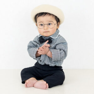 おしゃれな衣装で記念撮影をする赤ちゃん。ベレー帽とメガネが可愛いナチュラル系フォトスタジオでのバースデーフォト