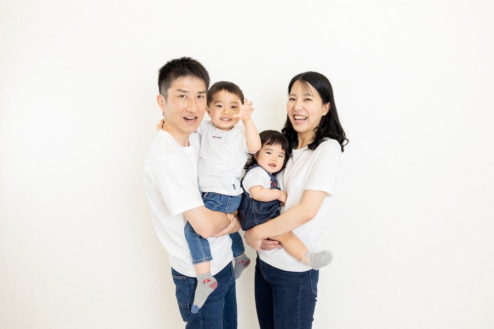 1歳のバースデーフォト。赤ちゃんの笑顔と、パパママに囲まれた明るい家族写真