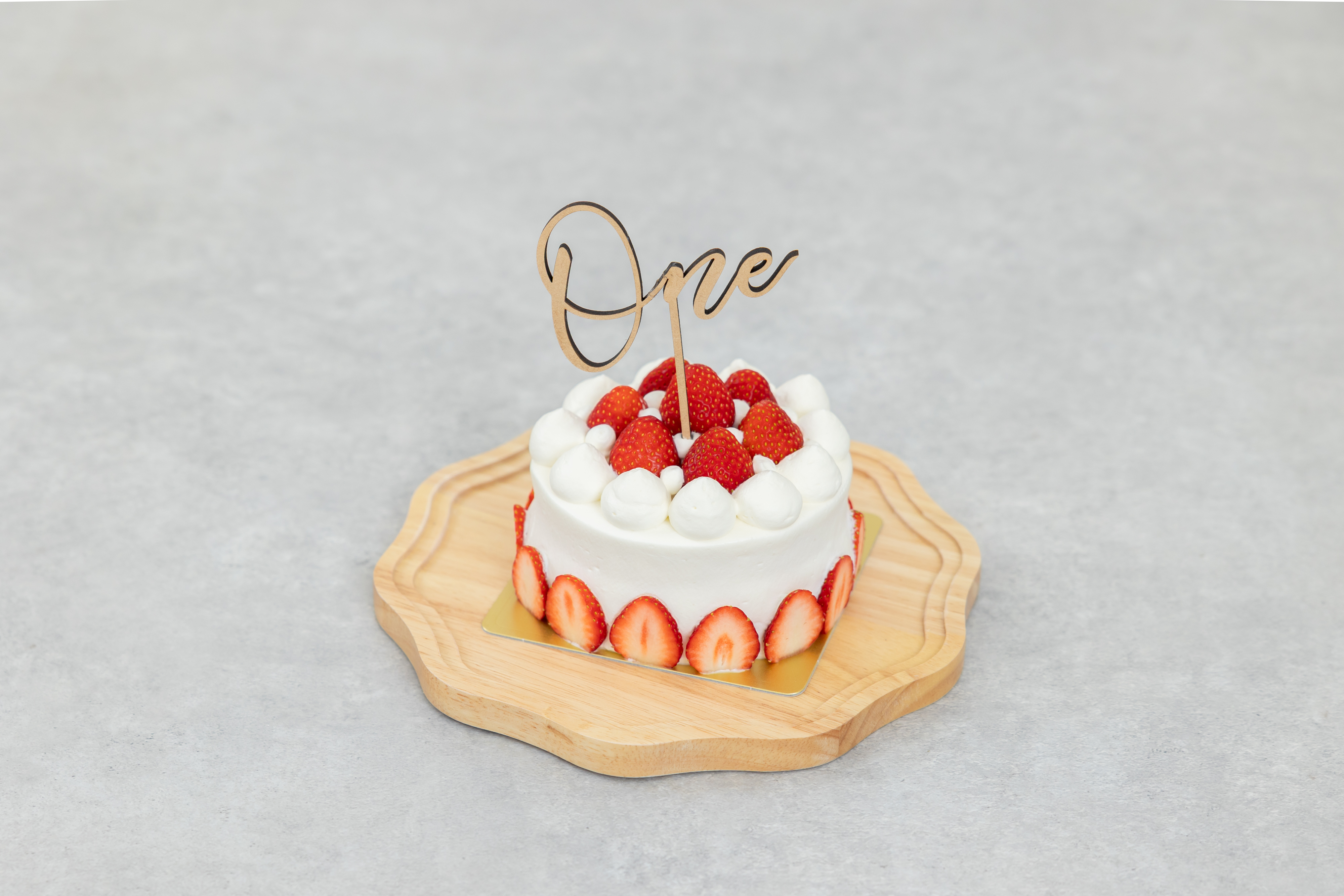いちごのショートケーキの上に、Oneのケーキトッパーがついている、スマッシュケーキ用のケーキ写真